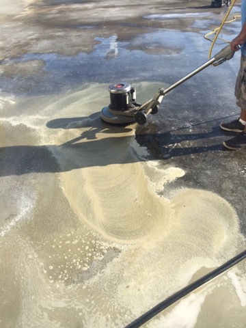 A rotary scrubber cleaning an exterior concrete walkway